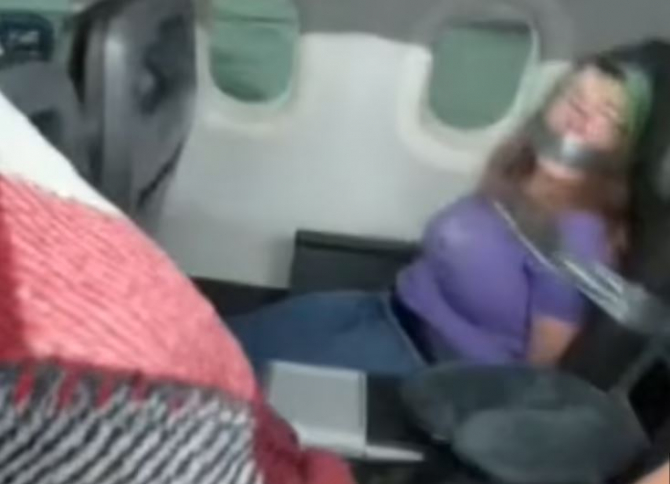 Scene șocante într-un avion. O femeie, legată cu bandă adezivă de scaun, după ce a atacat însoțitoarele de zbor 