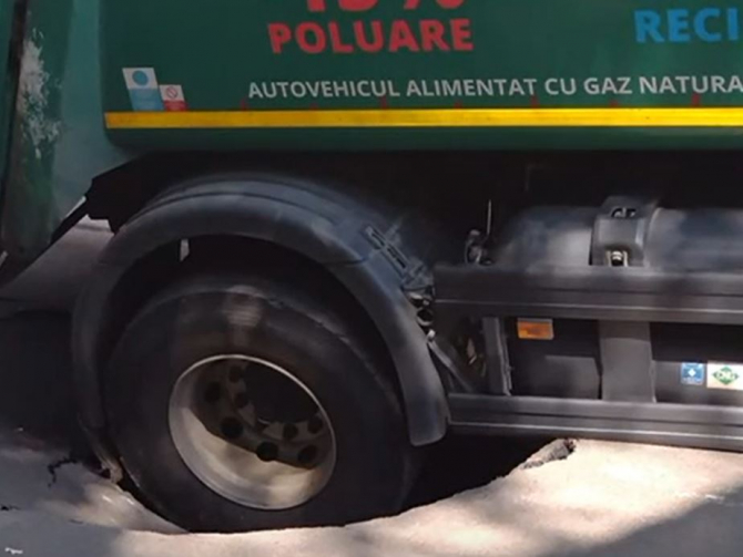 O mașină de salubrizare a rămas blocată în asfalt, după ce o stradă din București s-a surpat