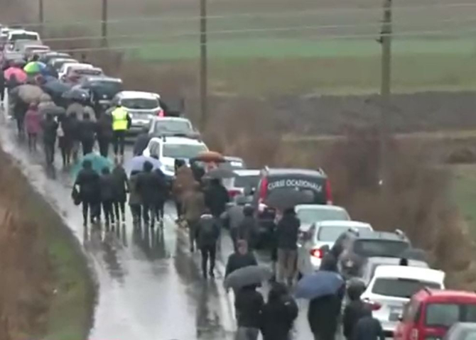 Mii de români merg 5 kilometri pe jos, prin ploaie, până la peștera Sfântul Andrei. Drumul, blocat de mașini și autocare