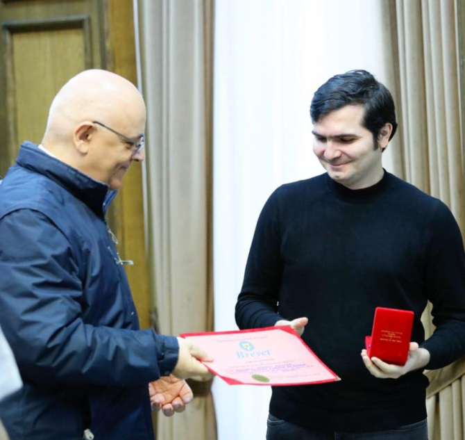 Bogdan Anicescu, interpretul de la conferințele Guvernului și ale MAI, a primit emblema de onoare a DSU. Sursa foto: facebook/DSU